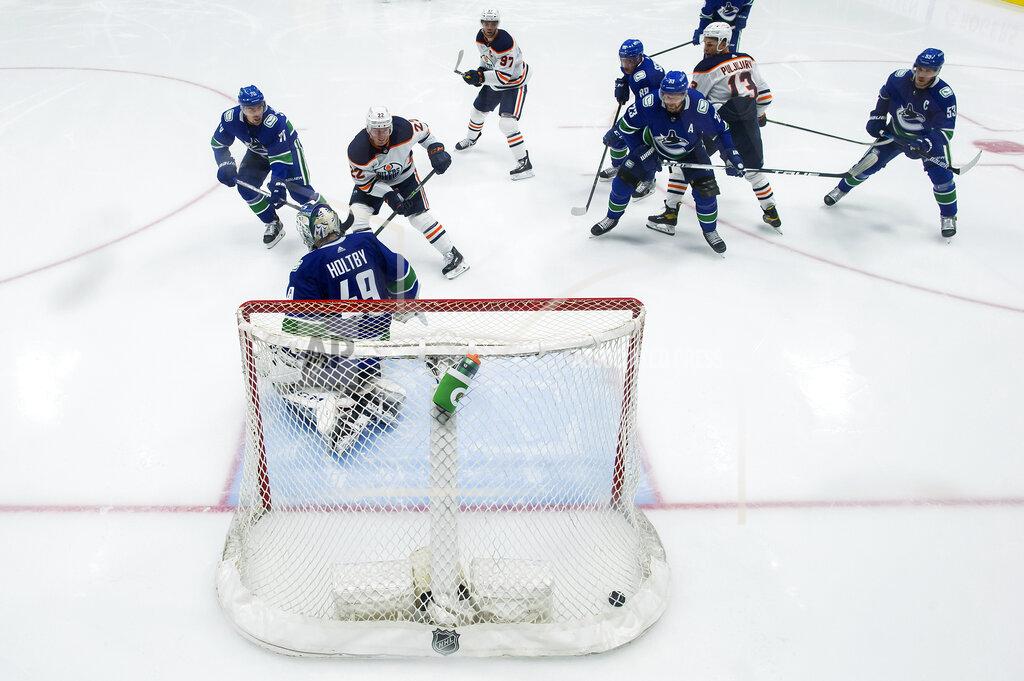Darryl Dyck Edmonton Oilers' Tyson Barrie (22) scores against Vancouver Canucks goalie Braden Holtby (49) during the second period of an NHL hockey game, Monday, May 3, 2021, in Vancouver, British Columbia. (Darryl Dyck/The Canadian Press via AP)