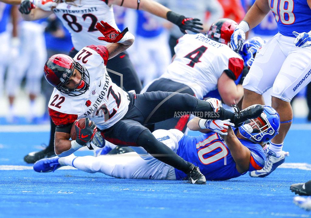 Steve Conner San Diego State running back Chase Jasmin (22) is tripped up by Boise State safety Kekoa Nawahine (10) in the first half of an NCAA college football game, Saturday, Oct. 6, 2018, in Boise, Idaho. (AP Photo/Steve Conner)