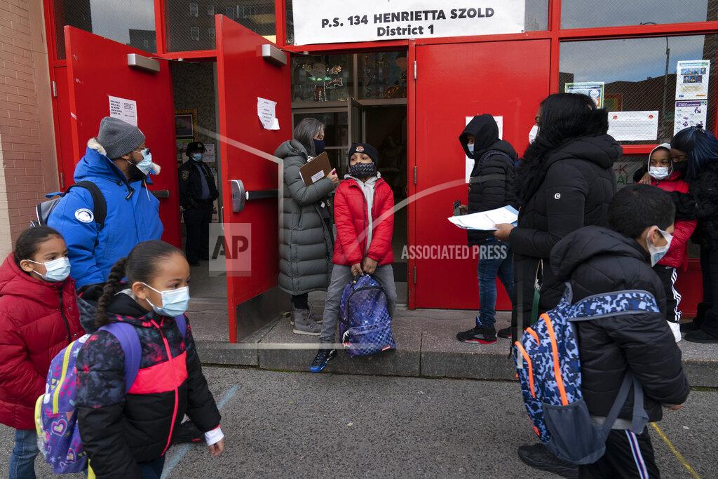 Mark Lennihan Students arrive at P.S. 134 Henrietta Szold Elementary School, Monday, Dec. 7, 2020, in New York. Public schools reopened for in-school learning Monday after being closed since mid-November. (AP Photo/Mark Lennihan)