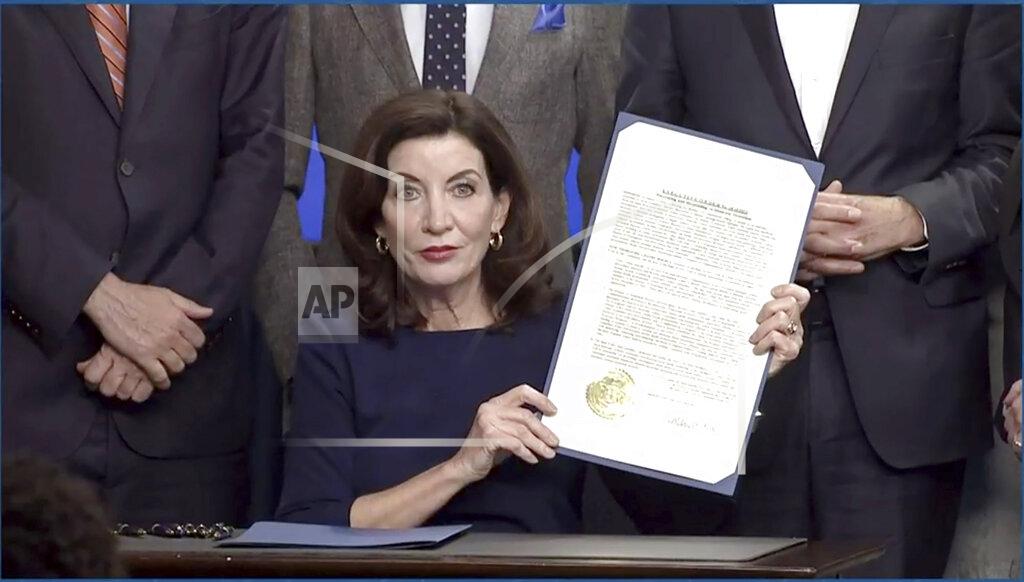 Uncredited In this image taken from video, New York Gov. Kathy Hochul shows an executive e order she signed during a news conference, Wednesday, May 18, 2022, in New York. New York would require state police to seek court orders to keep guns away from people who might pose a threat to themselves or others under a package of executive orders and gun control bills touted Wednesday by Hochul in the aftermath of a racist attack on a Buffalo supermarket. (Office of the Governor of New York via AP)