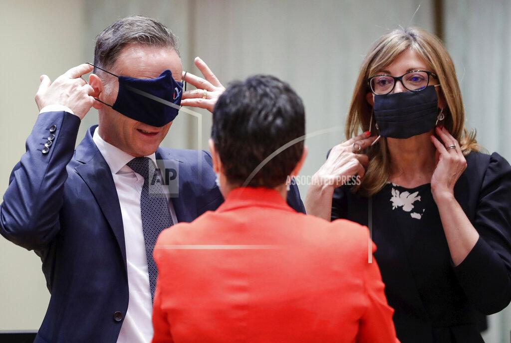 Stephanie Lecocq German Foreign Minister Heiko Maas, left, and Bulgaria's Foreign Minister Ekaterina Zharieva, right, put on their face masks, to prevent the spread of coronavirus, as they speak with Spain's Foreign Minister Arancha Gonzalez during an EU foreign ministers at the European Council building in Brussels, Monday, July 13, 2020. European Union foreign ministers meet for the first time face-to-face since the pandemic lockdown and will assess their discuss their relations with China and Turkey. (Stephanie Lecocq, Pool Photo via Ap)