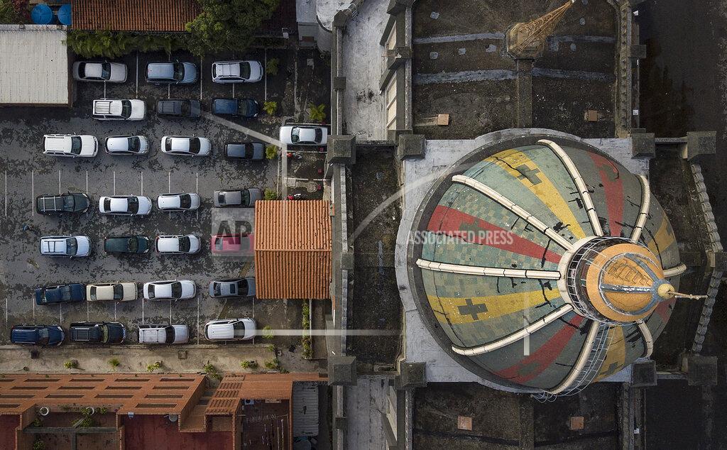 Matias Delacroix Parishioners stay in their cars during a drive-in Sunday Mass set up by Father Jonathan Gonzalez to circumvent the regulations that prevent concentrations in religious temples, imposed since March by the authorities to curb the spread of the new coronavirus, at the parking lot of the "Nuestra Señora de Coromoto" church in the El Paraiso neighborhood of Caracas, Venezuela, Sunday, Oct. 25, 2020. (AP Photo/Matias Delacroix)