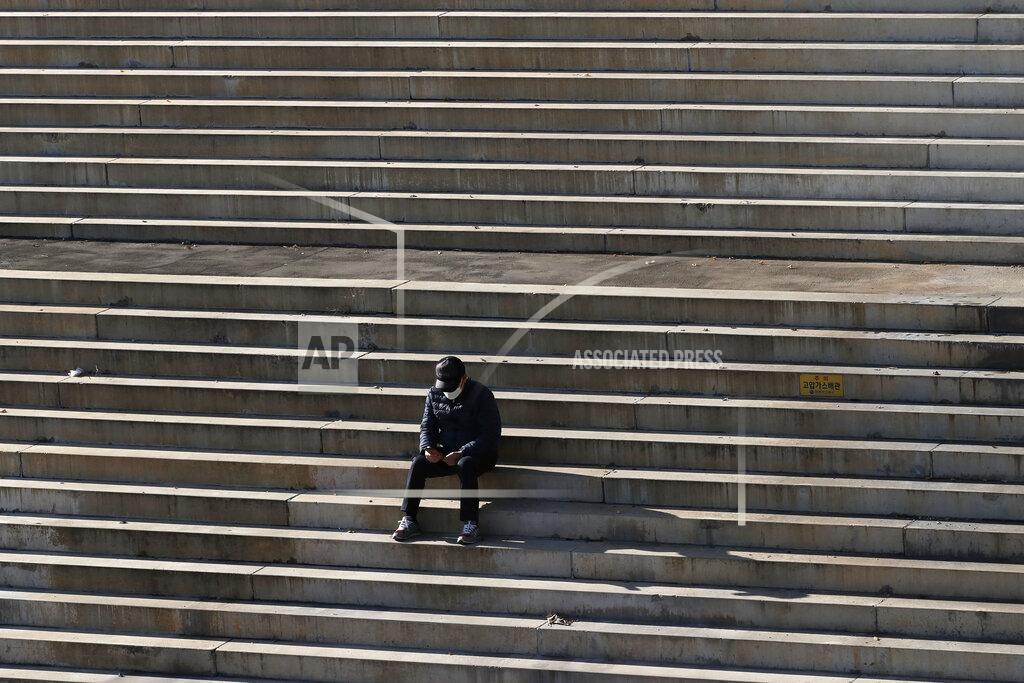 Lee Jin-Man A man wearing a face mask to help curb the spread of the coronavirus sits on a set of stairs in Seoul, South Korea, Monday, Nov. 23, 2020. (AP Photo/Lee Jin-man)