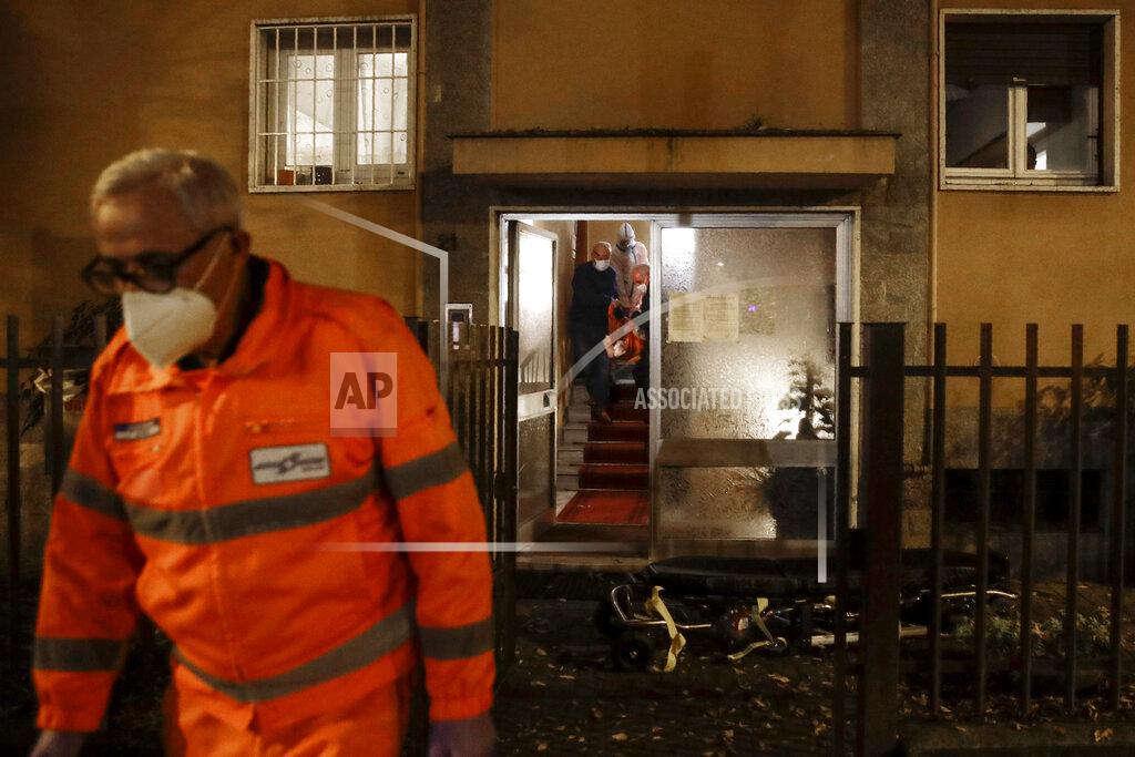 Luca Bruno Medical staffer Massimo Villa walks as a patient is carried on the stairs of her house during a shift with the emergency White Cross in Cinisello Balsamo, near Monza, Italy, Friday, Nov. 20, 2020. The city of Monza north of Milan is best known for its Formula 1 racetrack. In 2020, it has been the ambulance service that has been doing most of the racing. Over three days that an Associated Press photographer traveled on night calls with an ambulance service, the Monza-Brianza province of some 875,000 bordering Milan added 2,500 new cases, part of Italy’s new epicenter in the Lombardy region. (AP Photo/Luca Bruno)