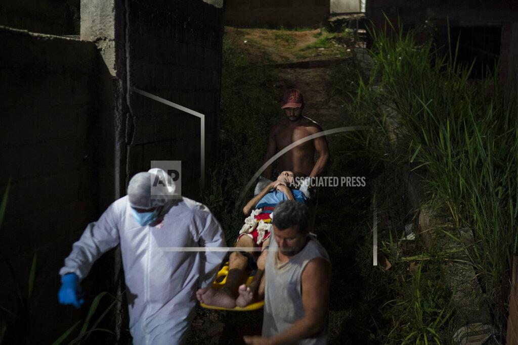 Felipe Dana Mobile Emergency Care Service (SAMU) worker Sergio Ricardo, left, and two neighbors, carry an elderly COVID-19 patient to an ambulance in Duque de Caxias, Rio de Janeiro state, Brazil, Wednesday, April 7, 2021. (AP Photo/Felipe Dana)