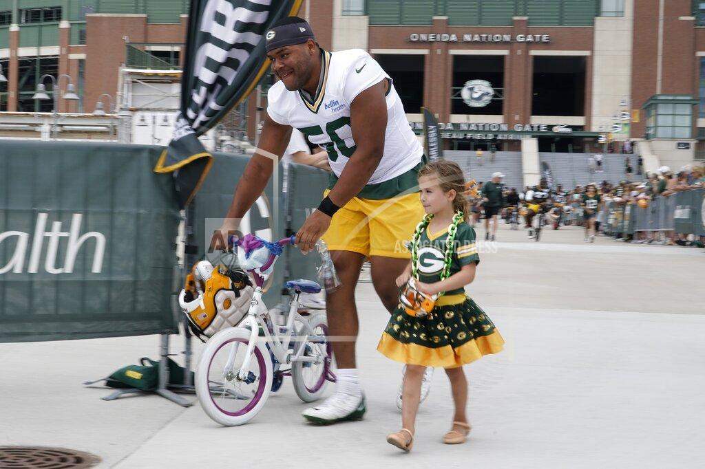Morry Gash Green Bay Packers' Zach Tom walks a bike to the NFL football team's practice field Wednesday, July 27, 2022, in Green Bay, Wis. (AP Photo/Morry Gash)
