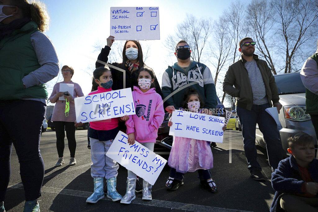 David Maialetti Barbara Roque, top left, holds up a sign during a Voice for Choice - Open Our Schools rally in Horsham, Pa., Sunday, Nov. 29, 2020. Joining her are her children, from left to right, Elaina, Emily, Erica and her husband, David. The group holding the event said their rally is about having the choice to choose from in-person Instruction or virtual. (David Maialetti/The Philadelphia Inquirer via AP)