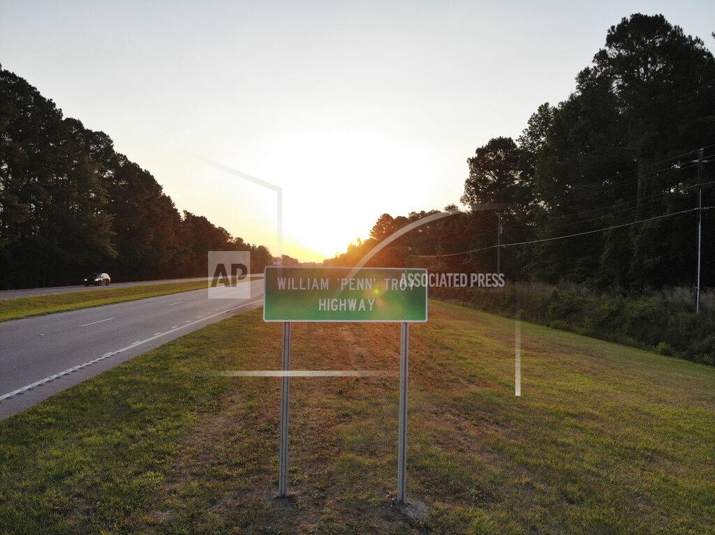 Allen G. Breed The sun rises behind a sign dedicating part of U.S. 76 in Mullins, S.C., to the late William Penn Troy Sr. on Monday, May 24, 2021. Over the years, Troy had served as a county commissioner, local school board member and church treasurer. But those were just his official duties. (AP Photo/Allen G. Breed)