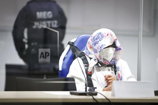 The 96-year-old defendant Irmgard F. sits in an ambulance chair behind a plexiglass screen in a courtroom in Itzehoe, Germany, Tuesday, Oct. 19, 2021. The woman is charged of more than 11,000 counts of accessory to murder. Prosecutors argue that the 96-year-old woman was part of the apparatus that helped the Nazi camp function more than 75 years ago. (Christian Charisius/DPA via AP, Pool)