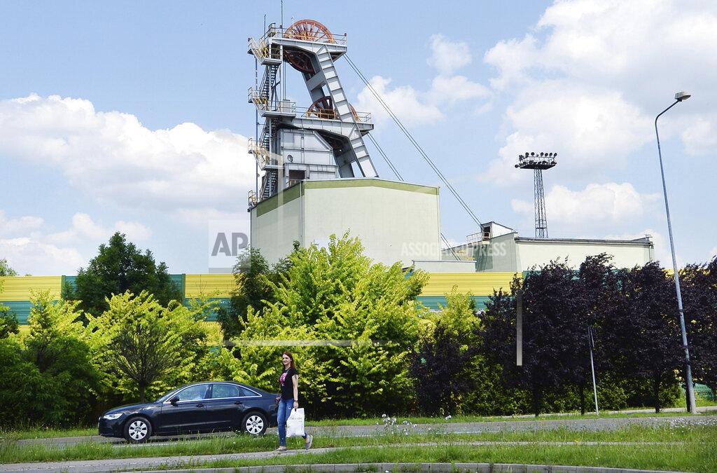 Czarek Sokolowski A woman passes the Wujek coal mine in the Polish region of Silesia during a pause in operations in Katowice, Poland, Saturday, July 4, 2020. The coronavirus has ripped through Poland's coal mines, paralyzing an already-troubled industry, forcing many to stay home from work and triggering a three-week closure of many state-run mines. (AP Photo/Czarek Sokolowski)