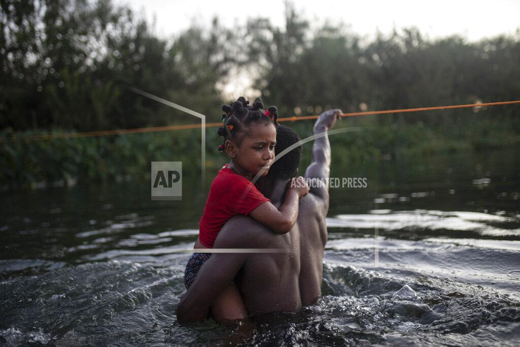 Felix Marquez Migrants wade across the Rio Grande from Del Rio, Texas, to Ciudad Acuña, Mexico, Sunday, Sept. 19, 2021. (AP Photo/Felix Marquez)
