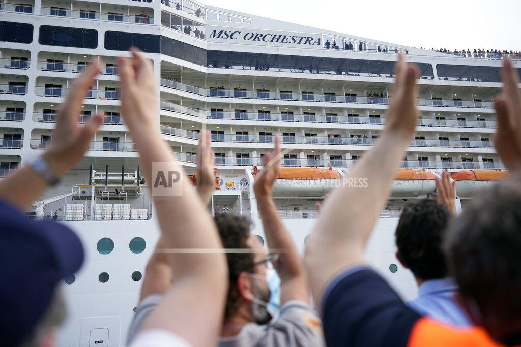 Antonio Calanni People applaud as the 92,409-ton, 16-deck MSC Orchestra cruise ship departs from Venice, Italy, Saturday, June 5, 2021. The first cruise ship leaving Venice since the pandemic is set to depart Saturday amid protests by activists demanding that the enormous ships be permanently rerouted out the fragile lagoon, especially Giudecca Canal through the city's historic center, due to environmental and safety risks. The cruiser passed two groups of protesters: pro-cruise advocates whose jobs depend on the industry as well as protesters belonging to a movement called "No Big Ships" who have been campaigning for years to get cruise ships out of the lagoon. (AP Photo/Antonio Calanni)