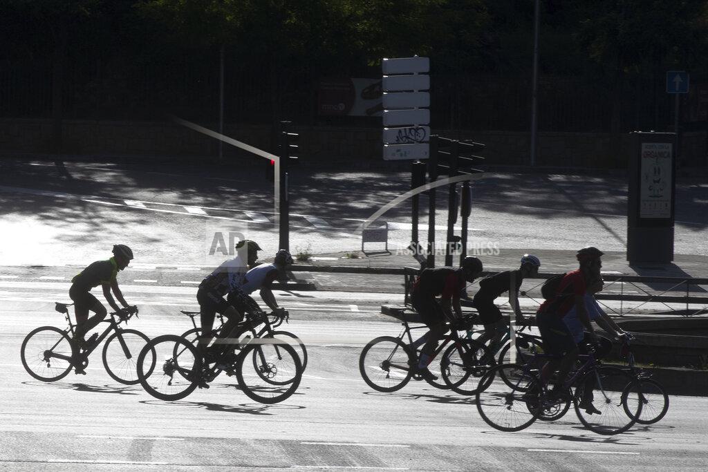 Paul White In this photo taken on Sunday May 3, 2020, a group of cyclists, many on racing bikes, ride down the Paseo de la Castellana boulevard in Madrid, Spain after Spaniards were able to go outdoors to do exercise for the second time in seven weeks since the lockdown began to battle the coronavirus outbreak. High-performance athletes were allowed to resume training this week but some reported being harassed by local residents who thought they were breaking confinement rules. (AP Photo/Paul White)