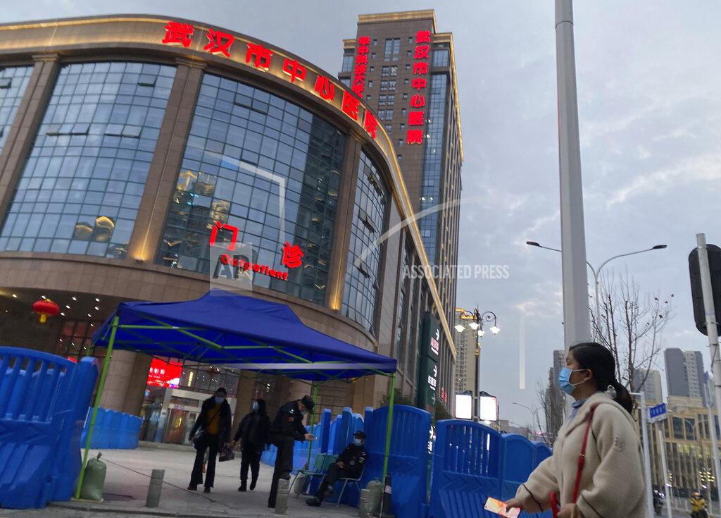 Security guards watch over the entrance of the Wuhan Central Hospital where Li Wenliang, the whistleblower doctor who sounded the alarm and was reprimanded by local police for it in the early days of Wuhan's pandemic, worked, in central China's Hubei province, Saturday, Feb. 6, 2021. Dr. Li Wenliang died in the early hours of Feb. 7 from the virus first detected in this Chinese city. A small stream of people marked the anniversary at the hospital. The 34-year-old became a beloved figure and a potent symbol in China after it was revealed that he was one the whistleblowers who authorities had punished early for “spreading rumors” about a SARS-like virus. (AP Photo/Ng Han Guan)
