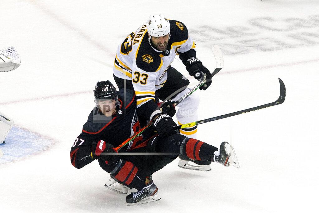 Chris Young Carolina Hurricanes' Andrei Svechnikov (37) is taken down by Boston Bruins' Zdeno Chara (33) during third period NHL Eastern Conference Stanley Cup playoff game in Toronto on Saturday, Aug. 15, 2020. (Chris Young/The Canadian Press via AP)