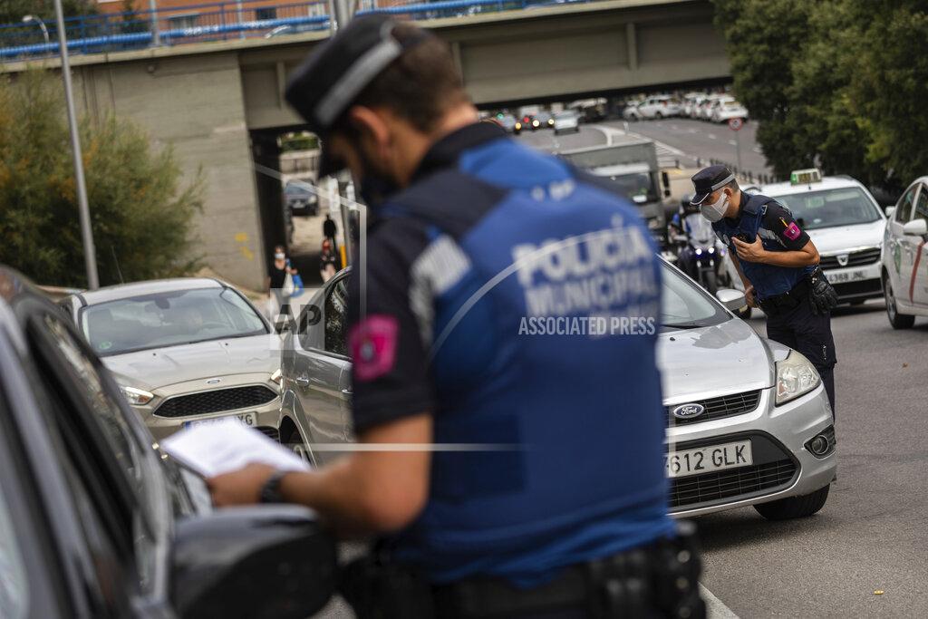 Bernat Armangue Local police stop vehicles at a checkpoint in Madrid, Spain, Wednesday, Sept. 23, 2020. Madrid is poised to extend its restrictions on movement to more neighborhoods, due to a surge in new cases in other districts and despite an outcry from residents over discrimination. Police on Monday deployed to 37 working-class neighborhoods that have seen 14-day transmission rates above 1,000 per 100,000 inhabitants. (AP Photo/Bernat Armangue)