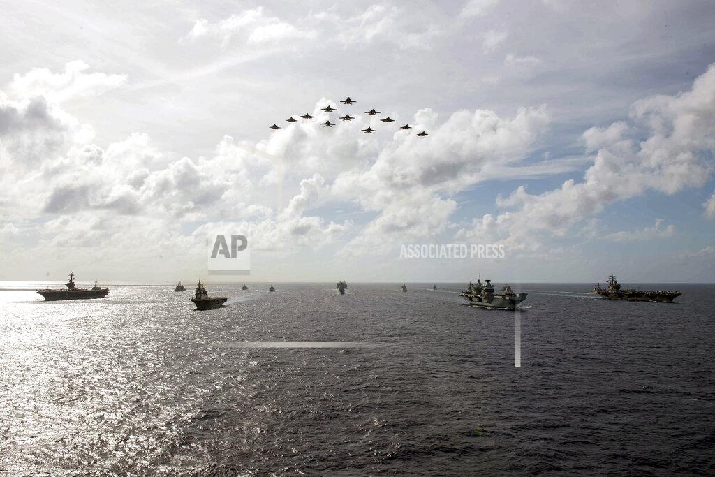 Michael Jarmiolowski In this photo released by the U.S. Indo-Pacific Command, the United Kingdom's carrier strike group led by HMS Queen Elizabeth (R 08), and Japan Maritime Self-Defense Forces led by (JMSDF) Hyuga-class helicopter destroyer JS Ise (DDH 182) joined with U.S. Navy carrier strike groups led by flagships USS Ronald Reagan (CVN 76) and USS Carl Vinson (CVN 70) to conduct multiple carrier strike group operations in the Philippine Sea, on OCt. 3, 2021. After sending a record number of military aircraft to harass Taiwan over China’s National Day holiday weekend, Beijing has toned down the sabre rattling but tensions remain high, with the rhetoric and reasoning behind the exercises unchanged. (Michael Jarmiolowski/U.S. Navy via AP)