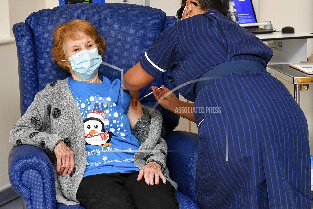 FILE - In this Tuesday Dec. 8, 2020 file photo, 90-year-old Margaret Keenan, the first patient in the U.K. to receive the Pfizer-BioNTech COVID-19 vaccine, receives an injection by nurse May Parsons at University Hospital, Coventry, England. On Friday, Dec. 11, 2020, The Associated Press reported on stories circulating online incorrectly asserting the first two recipients of the COVID-19 vaccine in Britain are “crisis actors.” Parsons first administered the vaccine to Keenan, then to “Bill” William Shakespeare. (Jacob King/Pool via AP)