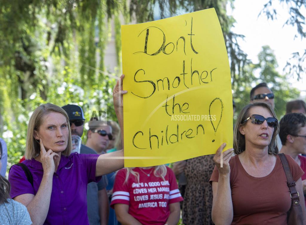 Rick Egan Protesters listen as commissioner Bill Lee speaks during a rally protesting against face masks being required in schools, before the Utah County Commission meeting in Provo, Utah, on Wednesday, July 15, 2020. County commissioners in Utah postponed the meeting Wednesday where they were expected to discuss mask mandates after people packed the room and ignored social distancing guidelines. Fox-13 reports that the Utah County commissioners cited public safety concerns as the reason for abruptly canceling the meeting. (Rick Egan/The Salt Lake Tribune via AP)