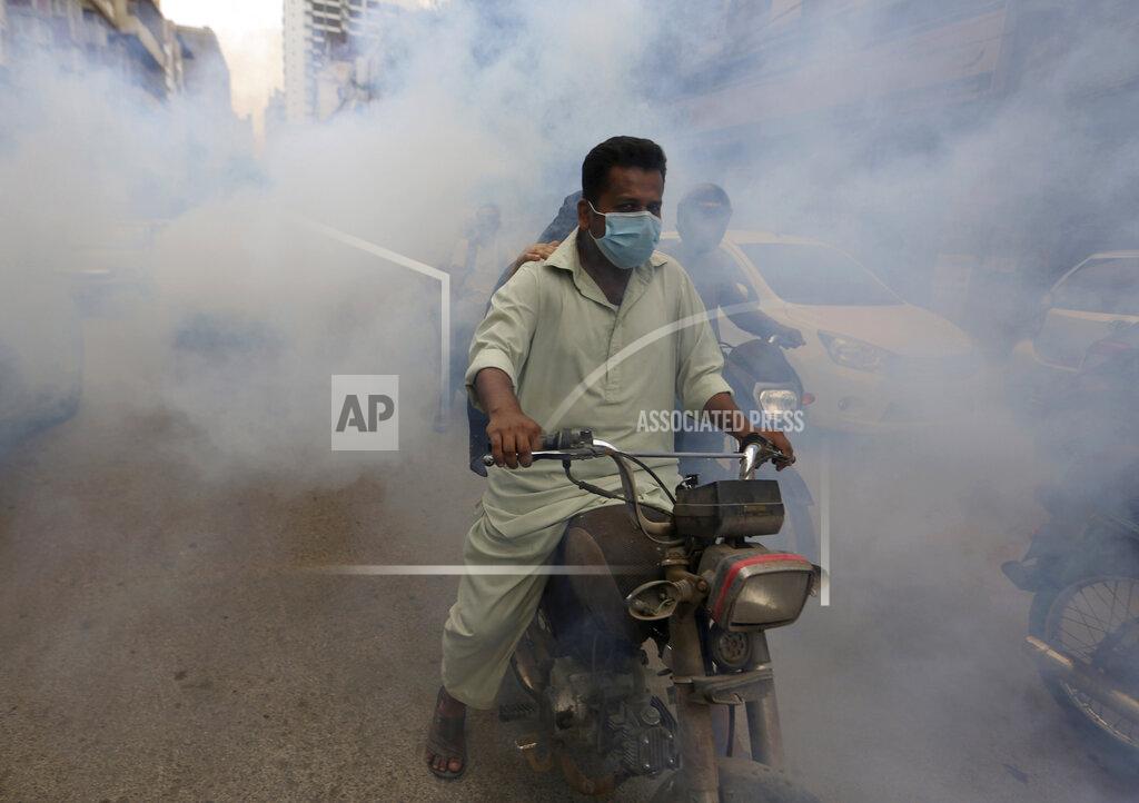 Fareed Khan Disinfectant is sprayed in a market area in an effort to contain the outbreak of the coronavirus, in Karachi, Pakistan, Monday, Aug. 2, 2021. (AP Photo/Fareed Khan)
