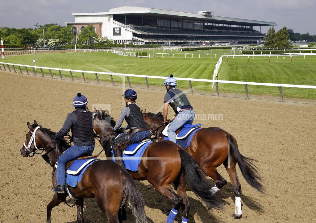 Seth Wenig FILE - In this June 6, 2019, file photo, riders workout with horses at Belmont Park in Elmont, N.Y. After a 4-year-old colt exhibited fever and neurological symptoms on Saturday, June 27, 2020, a barn at Belmont Park has been placed under a precautionary quarantine because of a suspected case of equine herpesvirus Type 1. (AP Photo/Seth Wenig, File)