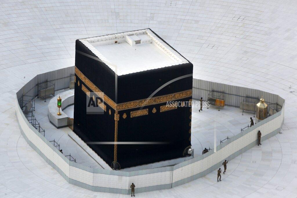 Amr Nabil FILE- In this March 6, 2020 file photo, Saudi policemen guard the the Kaaba, the cubic building at the Grand Mosque, in the Muslim holy city of Mecca, Saudi Arabia. The confirmed death toll from the coronavirus has gone over 50,000 in the Middle East as the pandemic continues. That's according to a count Thursday, Sept. 3, 2020, from The Associated Press, based on official numbers offered by health authorities across the region. (AP Photo/Amr Nabil, File)