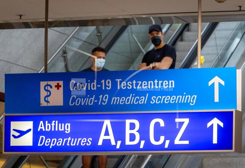 Michael Probst A sign recently fixed shows the way to the Covid-19 test center at the airport in Frankfurt, Germany, Saturday, Aug. 15, 2020. (AP Photo/Michael Probst)