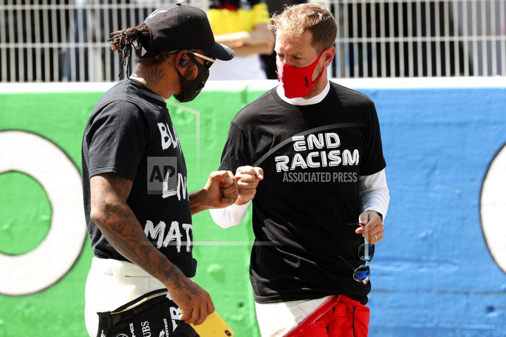 Albert Gea Mercedes driver Lewis Hamilton of Britain, left, welcomes Ferrari driver Sebastian Vettel of Germany prior to the Formula One Grand Prix at the Barcelona Catalunya racetrack in Montmelo, Spain, Sunday, Aug. 16, 2020. (Albert Gea, Pool via AP)