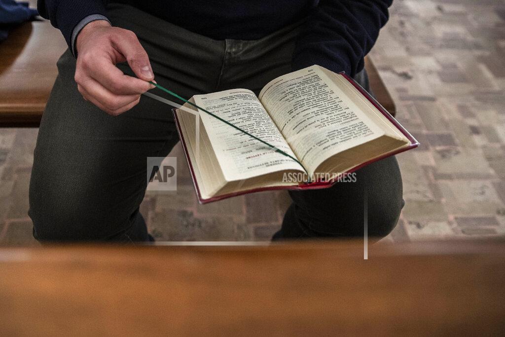 Seminarist Paolo Timpano reads a breviary as he prays at the San Giovanni Battista church in Rho, northern Italy on Friday, May 8, 2020. With coronavirus raging outside and inside Europe's largest diocesan seminary, the nearly 130 young men studying to become Catholic priests at the Seminario di Milano in northern Italy were confined strictly to their rooms for weeks. (AP Photo/Luca Bruno)