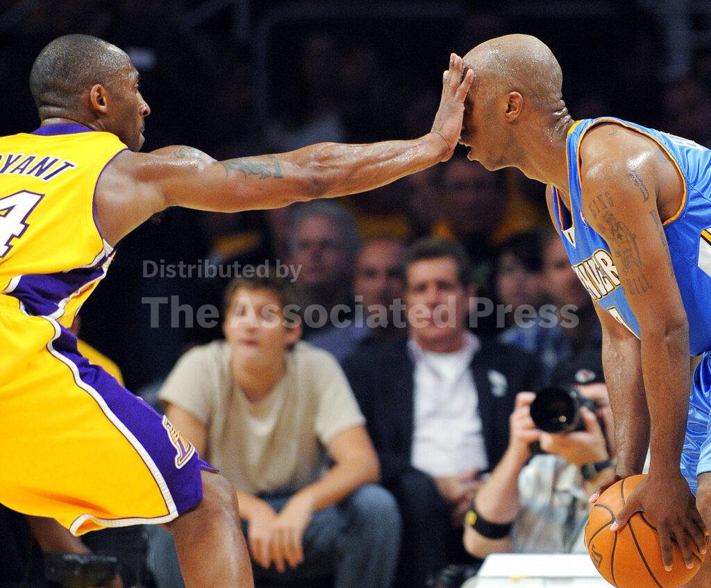 FILE - In this May 19, 2009, file photo, Los Angeles Lakers guard Kobe Bryant defends Denver Nuggets guard Chauncey Billups during the second half of Game 1 of the NBA basketball Western Conference finals, in Los Angeles. Bryant, the 18-time NBA All-Star who won five championships and became one of the greatest basketball players of his generation during a 20-year career with the Los Angeles Lakers, died in a helicopter crash Sunday, Jan. 26, 2020. (AP Photo/Mark J. Terrill, File)