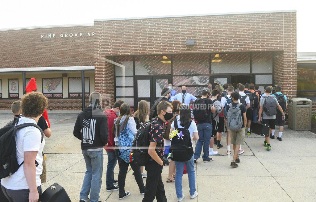 Jacqueline Dormer FILE—In this file photo from Aug. 27, 2020, Michael Janicelli, principal of Pine Grove Area High School, center, greets students as they arrive for the first day of school and enter the main doors at Pine Grove Area High School in Pine Grove, Pa. Gov. Tom Wolf will ask lawmakers Wednesday, Feb. 3, 2021, to raise income taxes on higher earners and give public schools a massive boost in aid, even as he faces a gaping deficit and uncertainty over how much more pandemic relief the federal government will send. (Jacqueline Dormer/Republican-Herald via AP)
