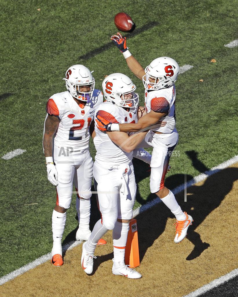 Chuck Burton Syracuse's Eric Dungey, center, celebrates his touchdown against Wake Forest with teammates Moe Neal, left, Sean Riley, in the second half of an NCAA college football game in Charlotte, N.C., Saturday, Nov. 3, 2018. (AP Photo/Chuck Burton)