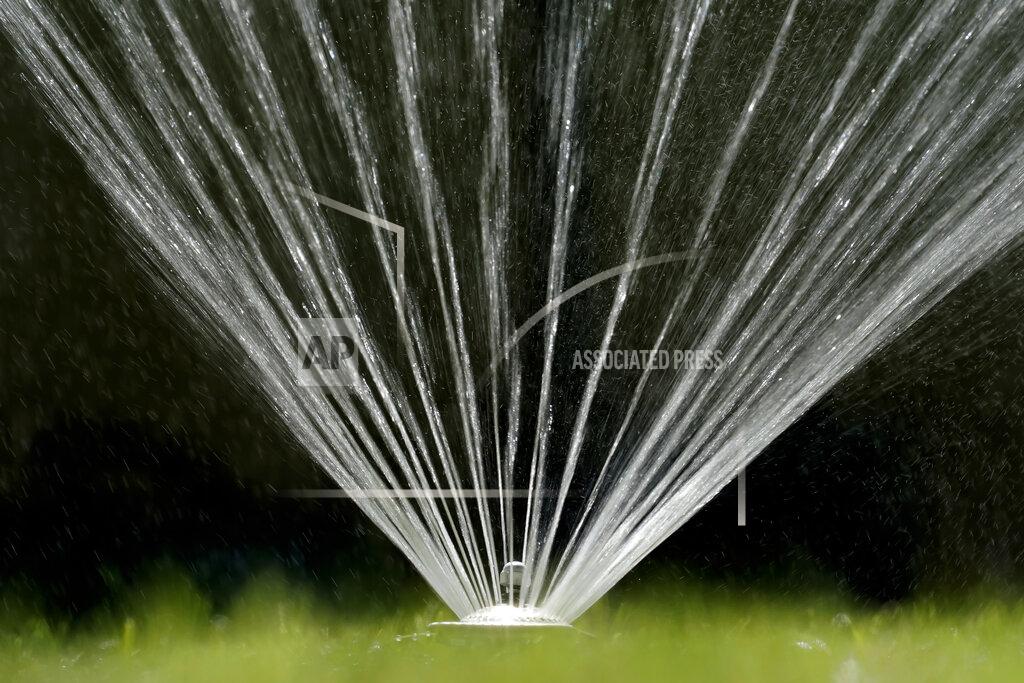 Rich Pedroncelli FILE - Water flies from a sprinkler on a lawn in Sacramento, Calif., on July 8, 2021. California Gov. Gavin Newsom threatened Monday, May 23, 2022, to impose mandatory, statewide restrictions on water use if people don't start using less on their own as the drought drags on and the hotter summer months approach. (AP Photo/Rich Pedroncelli, File)