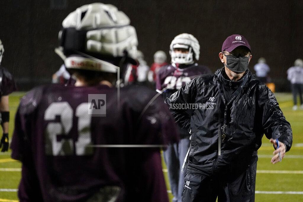 Ted S. Warren Jeff Housman, right, defensive coordinator at the University of Puget Sound, wears a mask as he talks with players during college football practice Tuesday, Feb. 2, 2021, in Tacoma, Wash. For all the attention heaped on the FBS level of college football last fall as it tried to play, it will not be the only college football during the 2020-21 sports calendar as a handful of NCAA Division III and NAIA programs begin some form of a winter/spring season Saturday, Feb. 6. (AP Photo/Ted S. Warren)