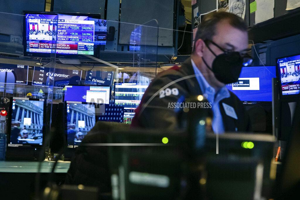 Colin Ziemer In this photo provided by the New York Stock Exchange, a trader works in a booth on the trading floor, Wednesday, Jan. 20, 2021. U.S. stocks are rallying to records Wednesday on encouraging earnings reports and continued optimism that new leadership in Washington will mean more support for the struggling economy. (Colin Ziemer/New York Stock Exchange via AP)