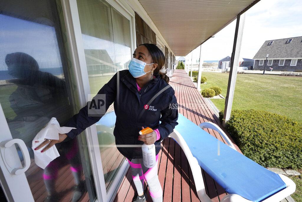 Steven Senne Worker Jennifer Porter, of Hyannis, Mass., cleans windows, Tuesday, April 6, 2021, at Red Jacket Resorts, in Yarmouth, Mass. Hotels, restaurants and other businesses in tourist destinations are warning that hiring challenges during the coronavirus pandemic could force them to pare back operating hours or curtail services just as they’re eyeing a bounce-back summer. (AP Photo/Steven Senne)