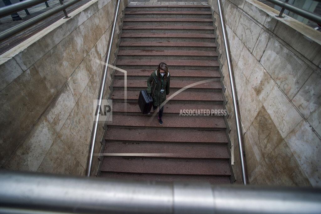 A woman wears a protective mask at the Astoria in Budapest, Hungary, Wednesday, Nov. 11, 2020. As a new element of government protection measures against the coronavirus epidemic, mask wearing is mandatory in some public areas of settlements with more than 10,000 inhabitants. (Zoltan Balogh/MTI via AP)