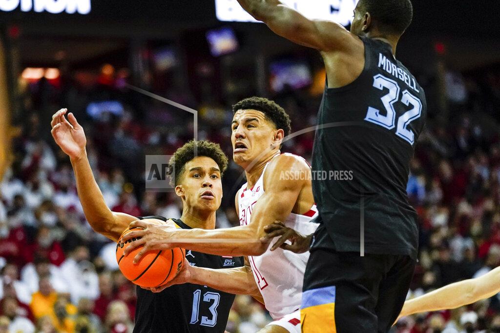 Andy Manis Wisconsin's Johnny Davis (1) drives between Marquette's Oso Ighodaro (13) and Darryl Morsell during the second half of an NCAA college basketball game Saturday, Dec. 4, 2021, in Madison, Wis. Davis had a game-high 25 points in Wisconsin's 89-76 win. (AP Photo/Andy Manis)