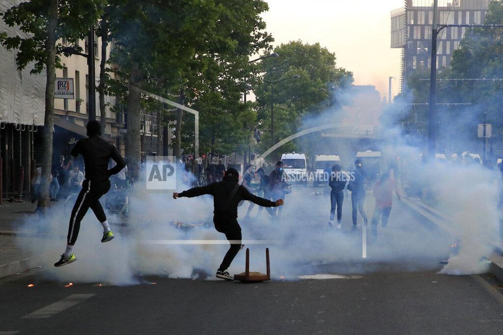 Michel Euler Protester kick in tear gas canisters during a demonstration Tuesday, June 2, 2020 in Paris. Thousands of people defied a police ban and converged on the main Paris courthouse for a demonstration to show solidarity with U.S. protesters and denounce the death of a black man in French police custody. The demonstration was organized to honor Frenchman Adama Traore, who died shortly after his arrest in 2016, and in solidarity with Americans demonstrating against George Floyd's death. (AP Photo/Michel Euler)