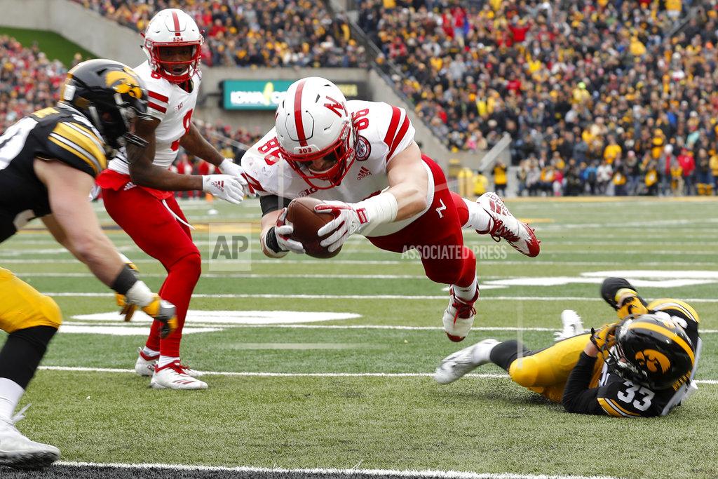 Charlie Neibergall Nebraska tight end Jack Stoll (86) dives to the end zone between Iowa defenders Jake Gervase, left, and Riley Moss, right, during a four-yard touchdown reception in the first half of an NCAA college football game, Friday, Nov. 23, 2018, in Iowa City, Iowa. (AP Photo/Charlie Neibergall)