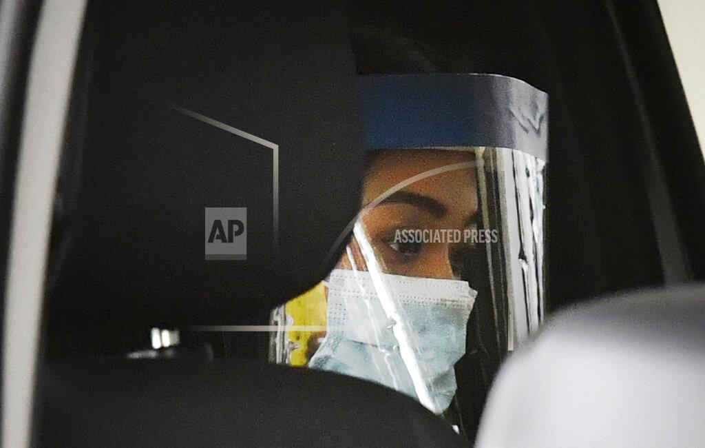 Darren England Sarah Caisip wears a protective mask after viewing her father's body at a funeral home in Brisbane, Thursday, Sept. 10, 2020. Caisip was refused permission to go to her father Bernard Prendergast's funeral because she was forced to spend 14 days in a hotel quarantine. (Darren England/AAP Image via AP)