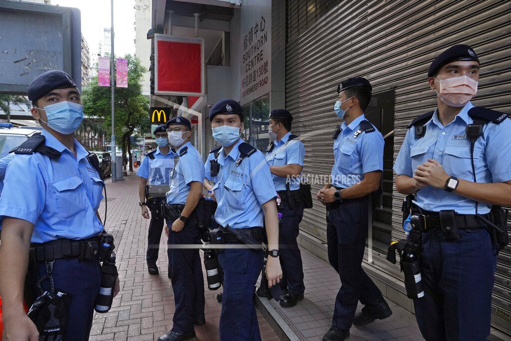 Vincent Yu Police officers stand guard at a street during a protest against an election committee that will vote for the city's leader in Hong Kong Sunday, Sept. 19, 2021. Hong Kong's polls for an election committee that will vote for the city's leader kicked off Sunday amid heavy police presence, with chief executive Carrie Lam saying that it is "very meaningful" as it is the first election to take place following electoral reforms. (AP Photo/Vincent Yu)