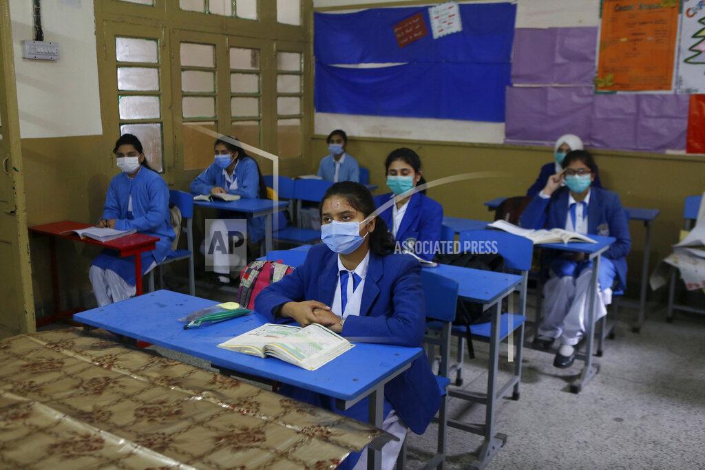 K.m. Chaudary Students wearing face masks to prevent the spread of the coronavirus attend their class at a school, in Lahore, Pakistan, Monday, Jan. 18, 2021. Pakistani authorities started to reopen schools in phases despite a steady increase in deaths and infections from the coronavirus, official said. (AP Photo/K.M.Chaudary)