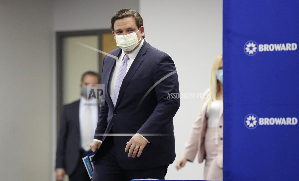 Florida Gov. Ron DeSantis arrives at a news conference, Monday, Aug. 3, 2020, at the Broward Health Corporate Office in Fort Lauderdale, Fla. On Friday, the governor's office released a video promoting "One Goal One Florida," a public service campaign that also urges Floridians to keep their distance and wear masks as a way to lower the risk of coronavirus infections. (AP Photo/Wilfredo Lee)