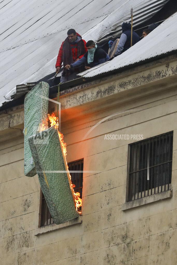Natacha Pisarenko Rioting inmates burn mattresses from the roof of the Villa Devoto prison to protest against authorities who they say are not doing enough to prevent the spread of coronavirus inside the jail in Buenos Aires, Argentina, Friday, April 24, 2020. (AP Photo/Natacha Pisarenko)