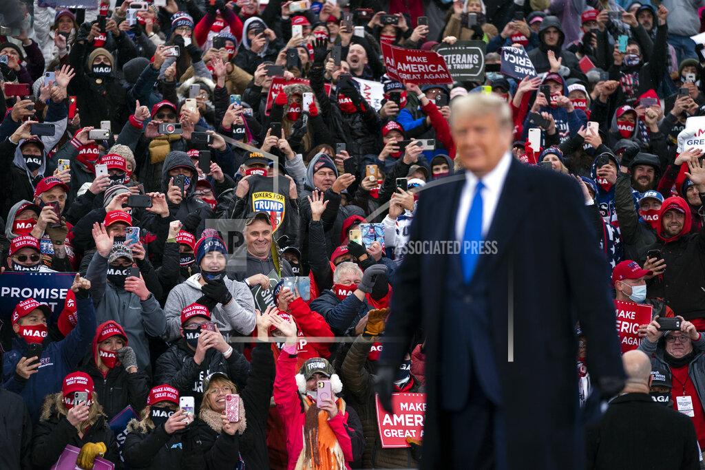 Evan Vucci Supporters cheer as President Donald Trump arrives at Capital Region International Airport for a campaign rally, Tuesday, Oct. 27, 2020, in Lansing, Mich. (AP Photo/Evan Vucci)