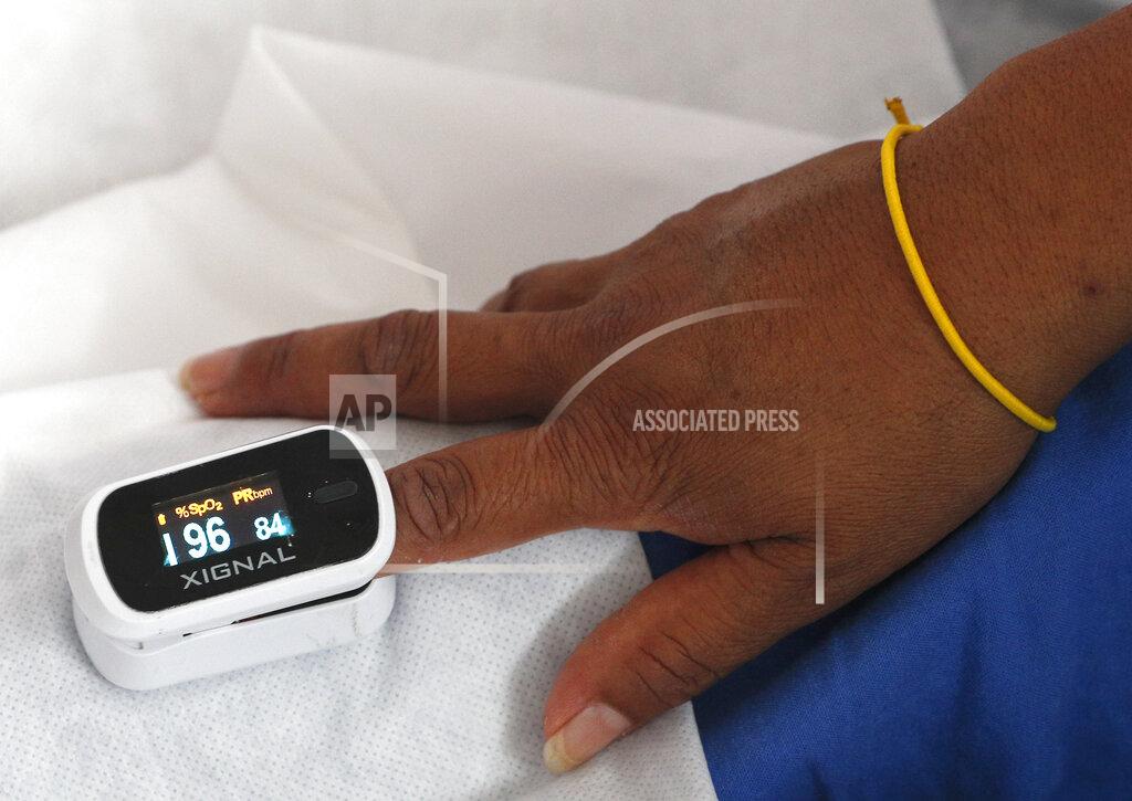 A patient has her blood oxygenation level checked in the women's ward of a COVID-19 hospital at Military Camp 1, Naucalpan, Mexico State, part of the Mexico City metropolitan area, Tuesday, June 23, 2020. Much of the expansion of beds for COVID-19 patients in Mexico has been at lower-level facilities that are not designed to handle serious cases. (AP Photo/Rebecca Blackwell)