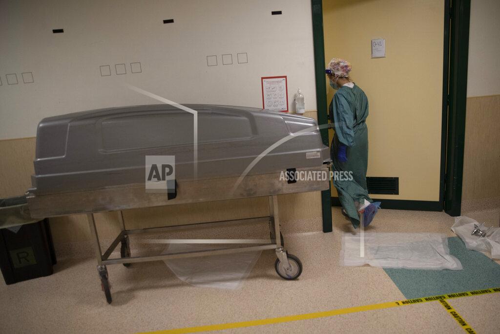 Alessandra Tarantino FILE - In this Nov. 7, 2020 file photo, a gurney containing a body of a patient who died overnight is seen in the sub-intensive COVID-19 unit of the Tor Vergata Polyclinic Hospital, in Rome. Italy is poised to reclaim the dishonor of reporting the most coronavirus deaths in Europe, as the second surge ravages the country’s disproportionately old population and exposes how public health shortfalls and delayed restrictions compounded a lack of preparedness going into the pandemic. (AP Photo/Alessandra Tarantino, file)