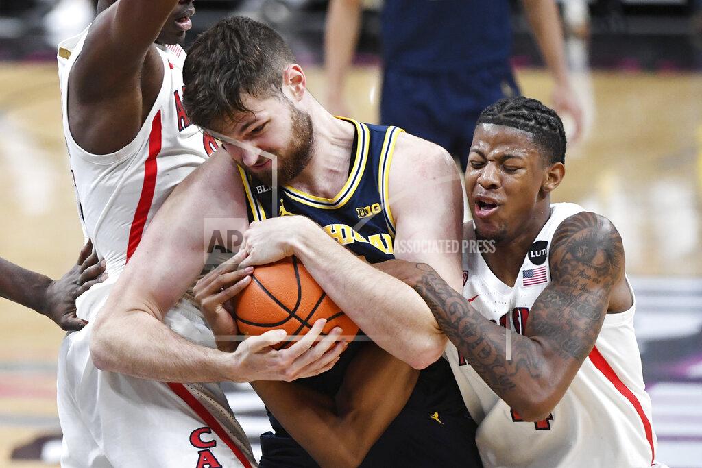 Sam Morris Michigan center Hunter Dickinson (1) and Arizona guard Dalen Terry (4) fight for a ball during an NCAA college basketball game Sunday, Nov. 21, 2021, in Las Vegas. (AP Photo/Sam Morris)