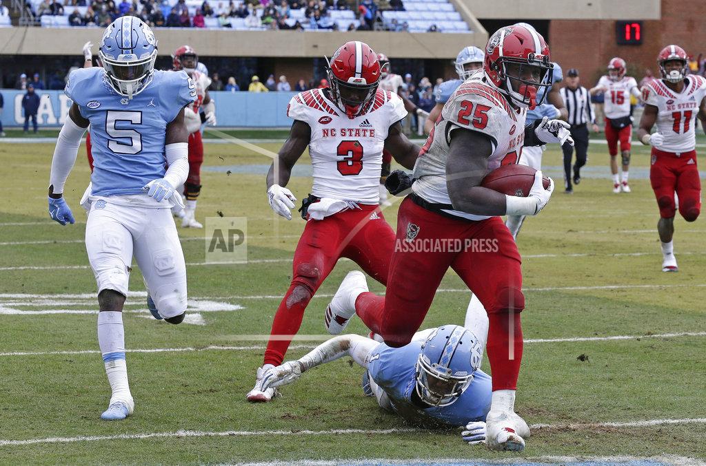 Gerry Broome North Carolina State's Reggie Gallaspy II (25) scores a touchdown as North Carolina's Patrice Rene (5) and Myles Dorn (1) chase during the second half of an NCAA college football game in Chapel Hill, N.C., Saturday, Nov. 24, 2018. North Carolina State won 43-28 in overtime. (AP Photo/Gerry Broome)